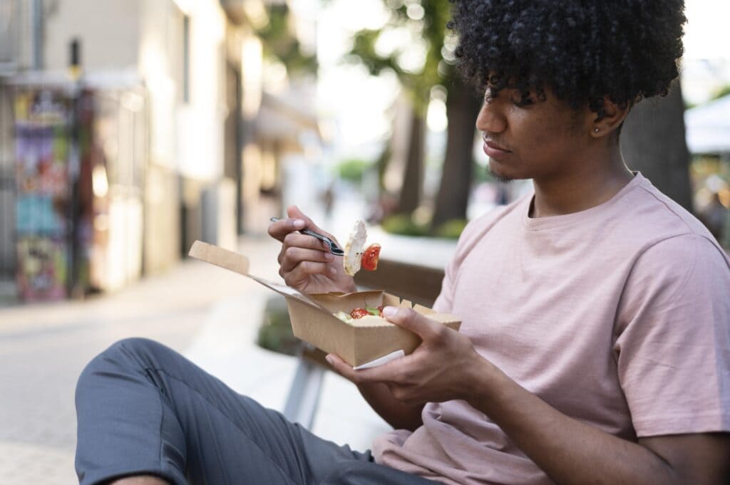 Person sitting at a table, mindfully eating a healthy meal with no distractions.